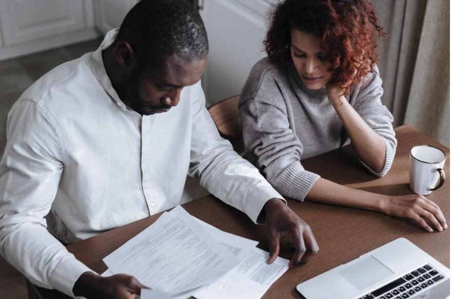 A couple reviewing health insurance paperwork together at their kitchen table